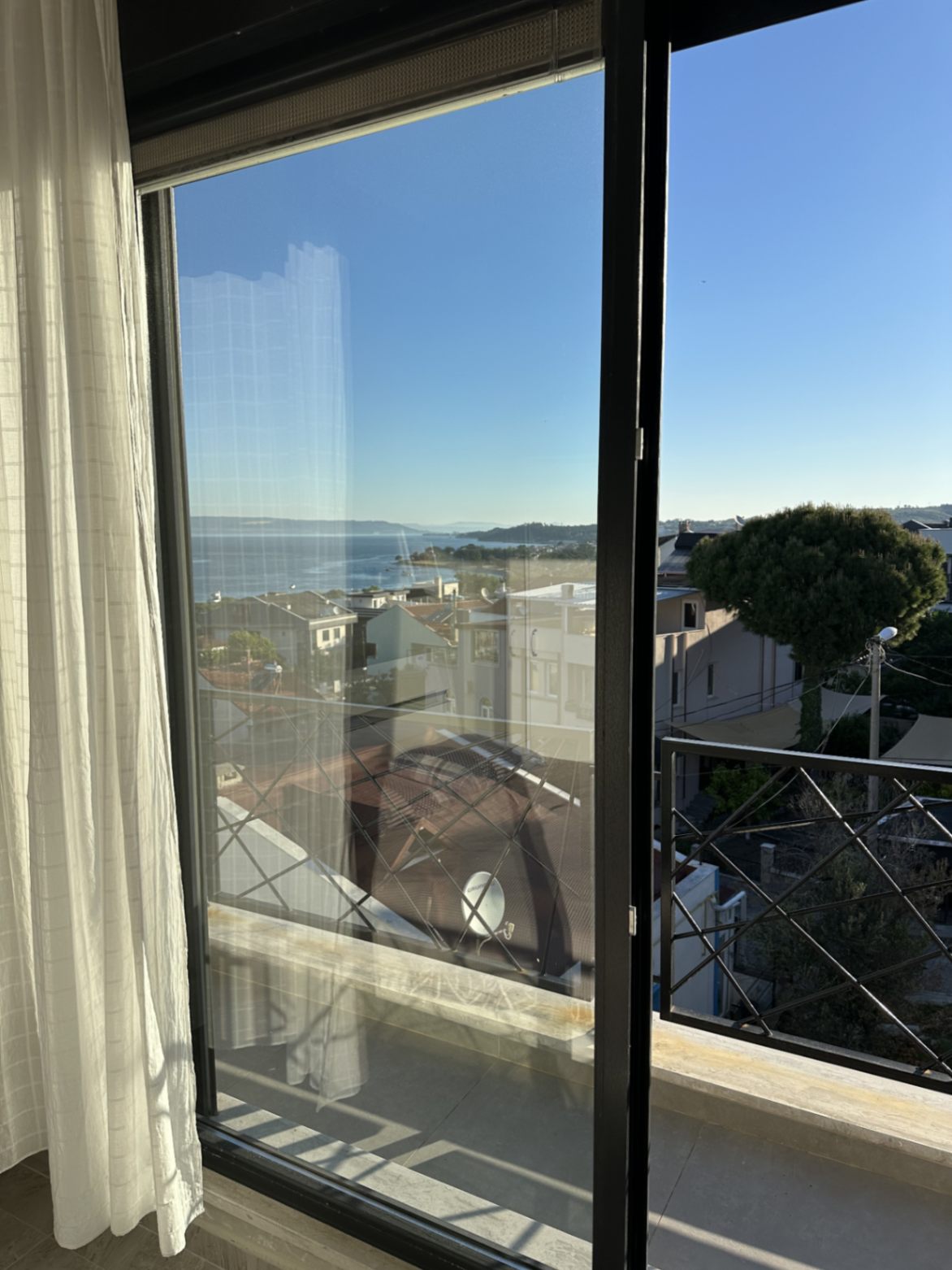 Balkon kapısından Güzelyalı çatıları ve Çanakkale Boğazı
