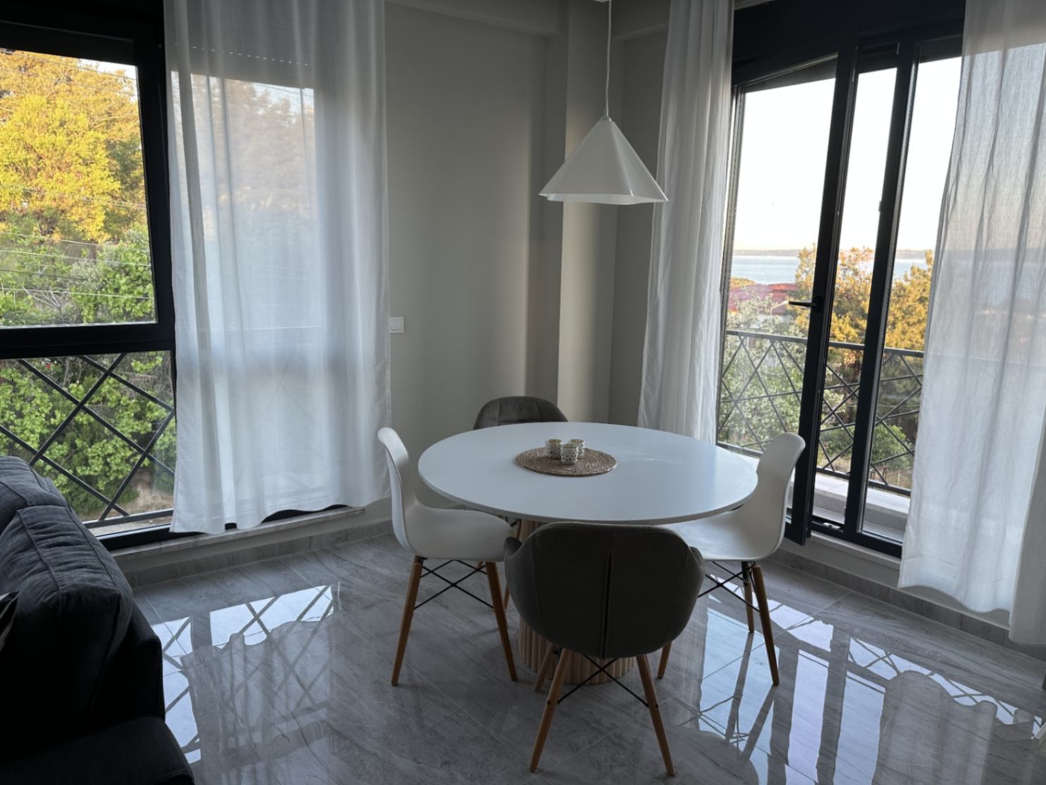 Yuvarlak yemek masası ve balkon kapısından görünen Çanakkale Boğazı