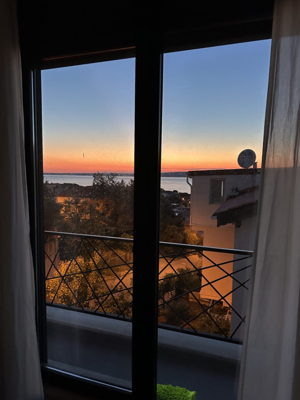 Balkon kapısından gün batımında Çanakkale Boğazı manzarası